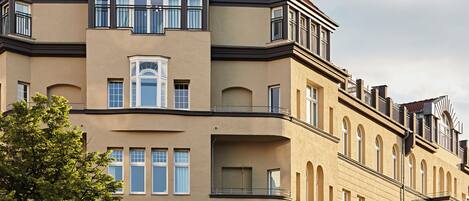 Un immeuble à plusieurs étages, doté d’une façade beige, de grandes fenêtres et de balcons.