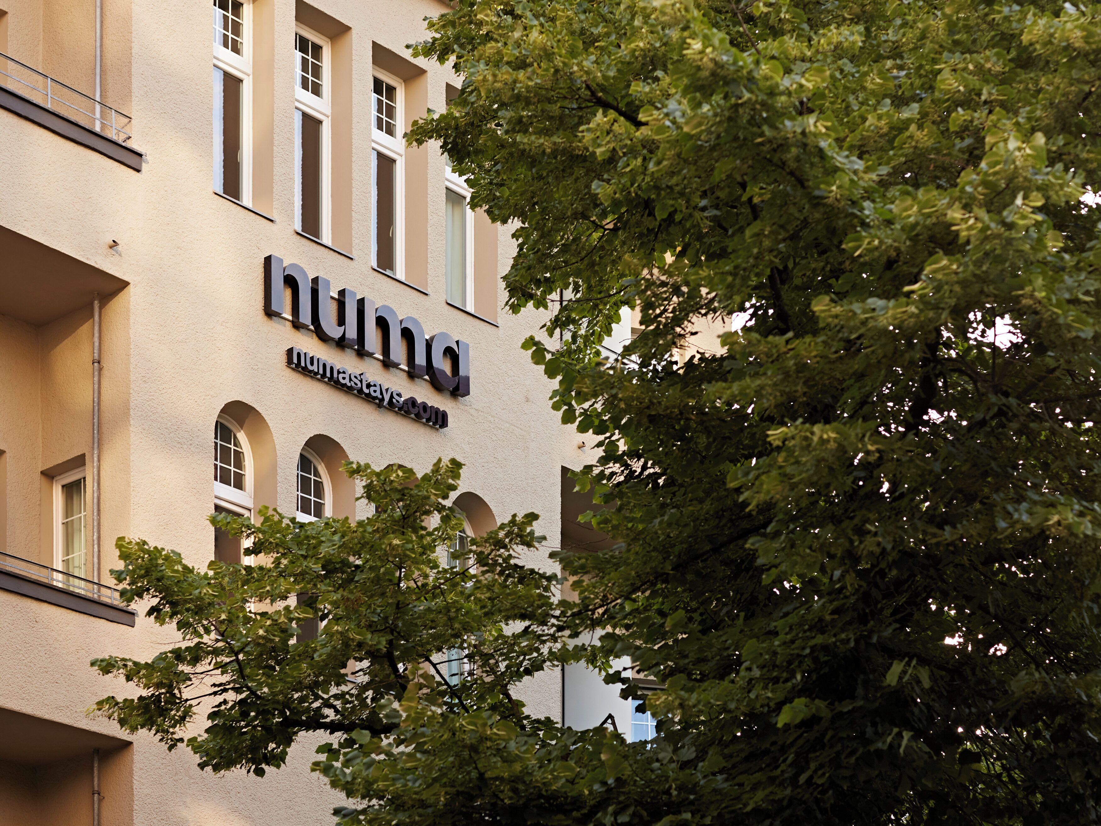 Un edificio con un letrero que dice 'numastays.com', indicando que es un hotel.