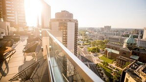 Un edificio alto con balcón de cristal que da a una vista panorámica de la ciudad.