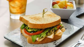 A sandwich with a toothpick on top, placed on a rectangular plate.