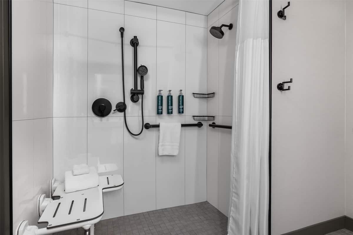 Un baño moderno con cabina de ducha, inodoro y tocador con espejo.