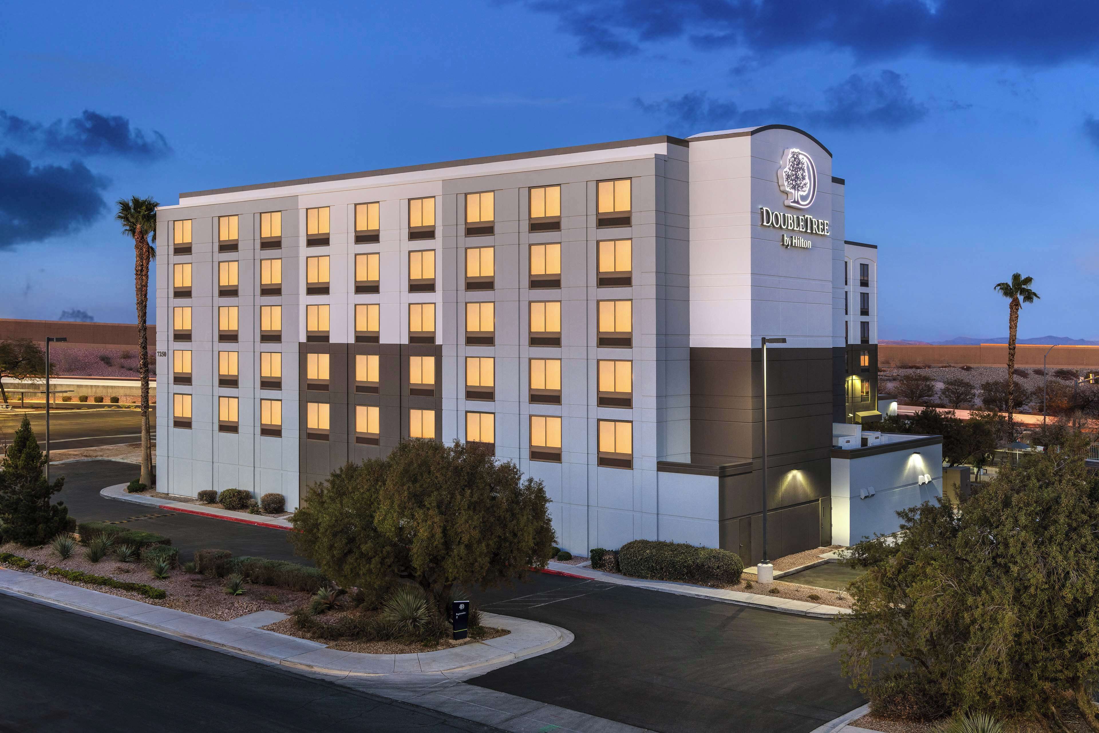 Un hotel moderno con fachada plana, múltiples ventanas y un letrero que indica que es un DoubleTree by Hilton.