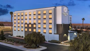 Un hotel moderno con fachada plana, múltiples ventanas y un letrero que indica que es un DoubleTree by Hilton.