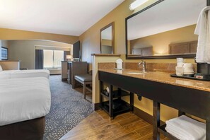 A hotel room with two beds, a desk, a large mirror, and a bathroom with a sink and toiletries. - Best Western Columbia River Waterfront Hotel Astoria (Astoria)