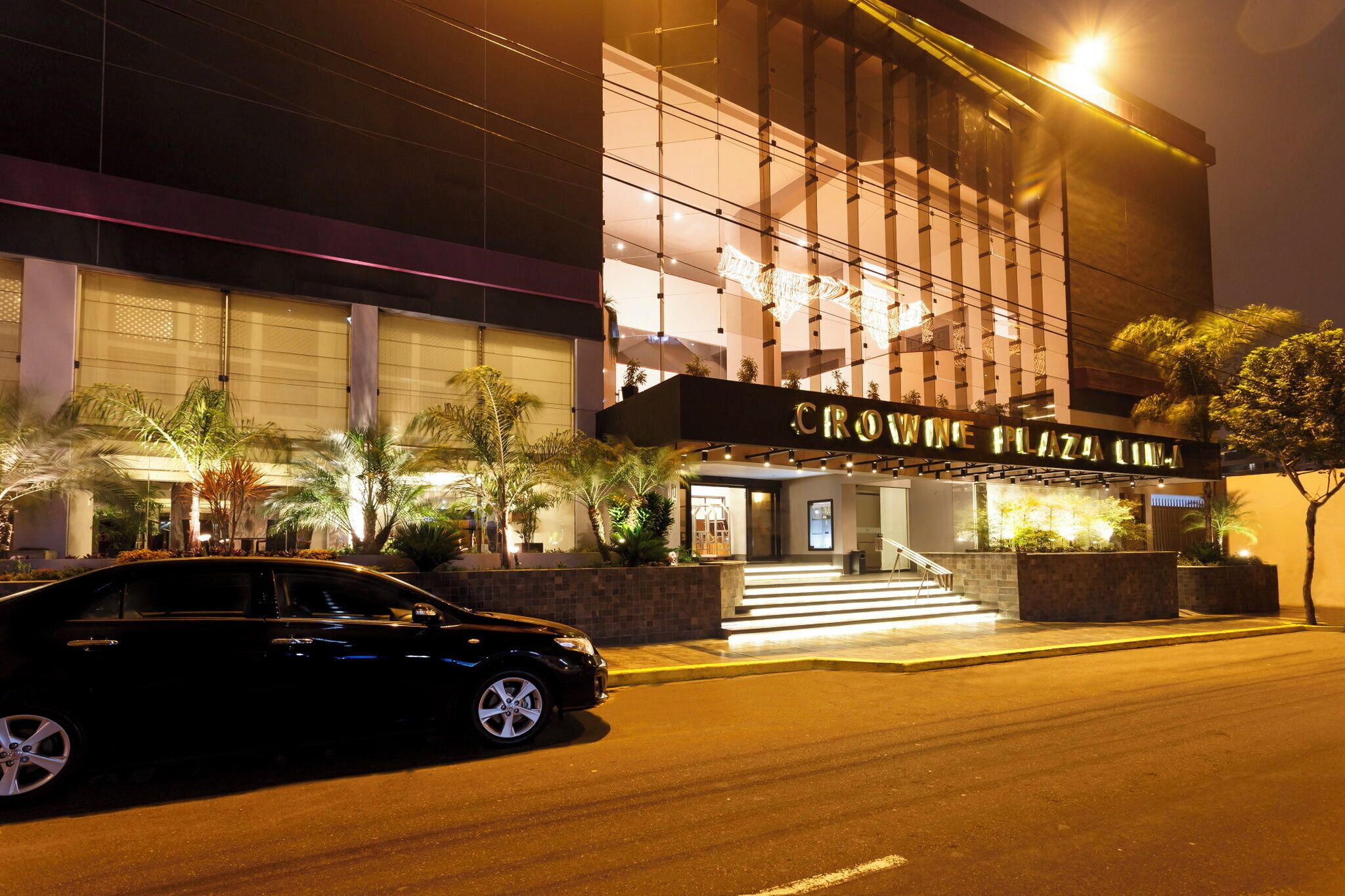 A building with a sign reading 'CROWNE PLAZA HOTEL' at night.