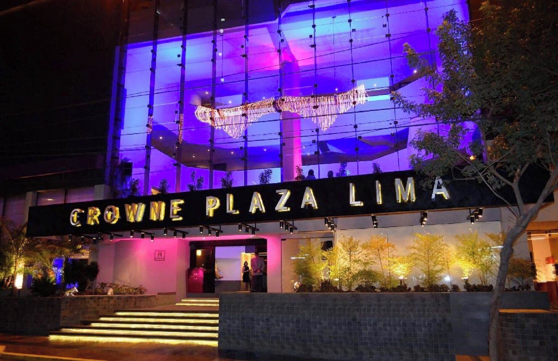The exterior of the Crowne Plaza Lima hotel with illuminated signage and a modern architectural design.