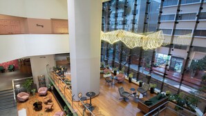 A spacious indoor area with multiple seating arrangements, including sofas and chairs, and a variety of tables. - Crowne Plaza Lima - Miraflores by IHG (Lima)