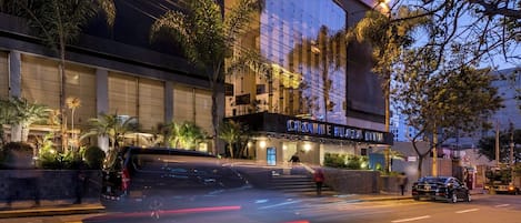 A building with a sign that reads 'Crown Plaza Hotel.'