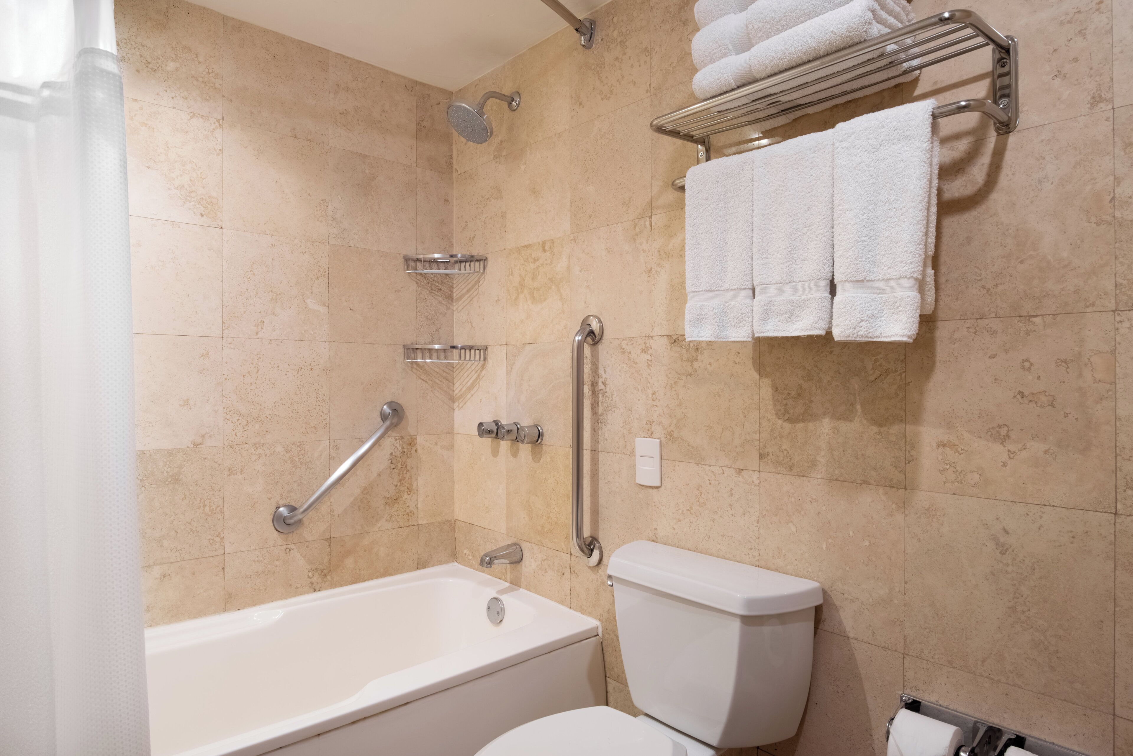 A bathroom with a bathtub, toilet, and shower.