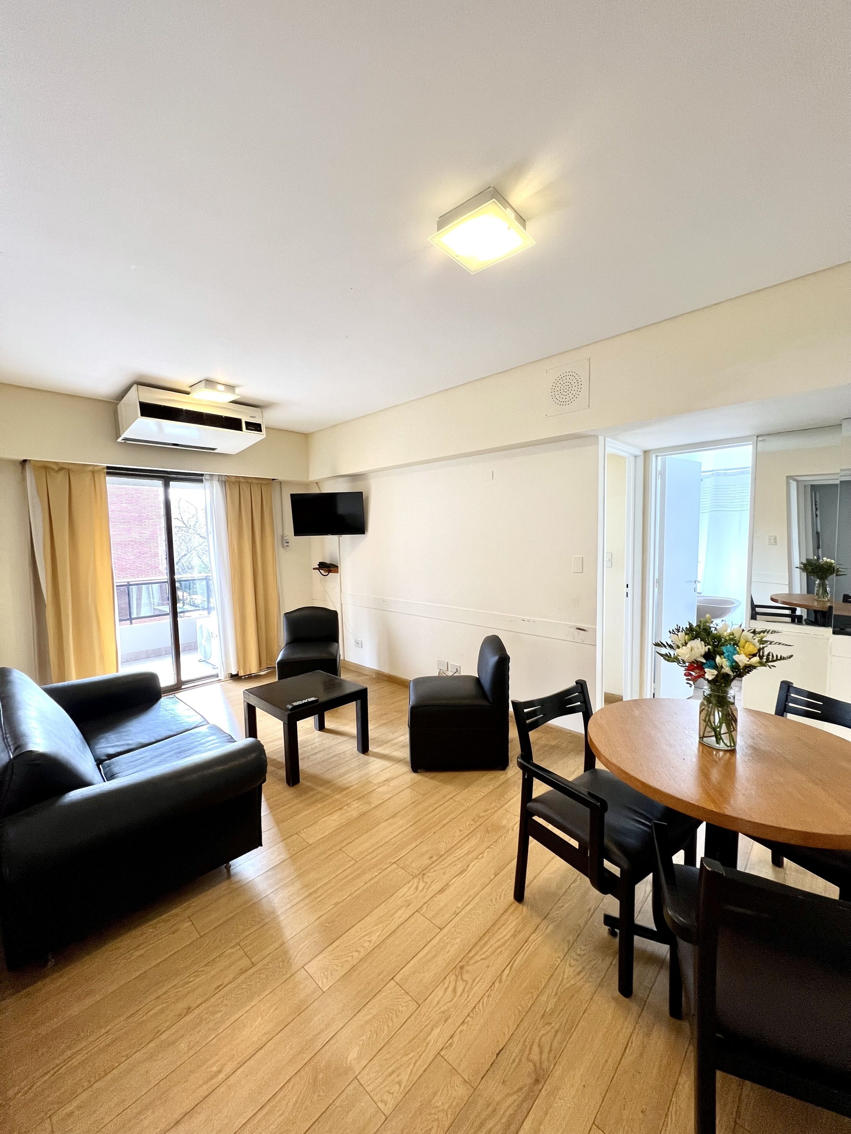 Un salon moderne comprenant un canapé, une table basse, un téléviseur et un coin repas avec une table et des chaises.