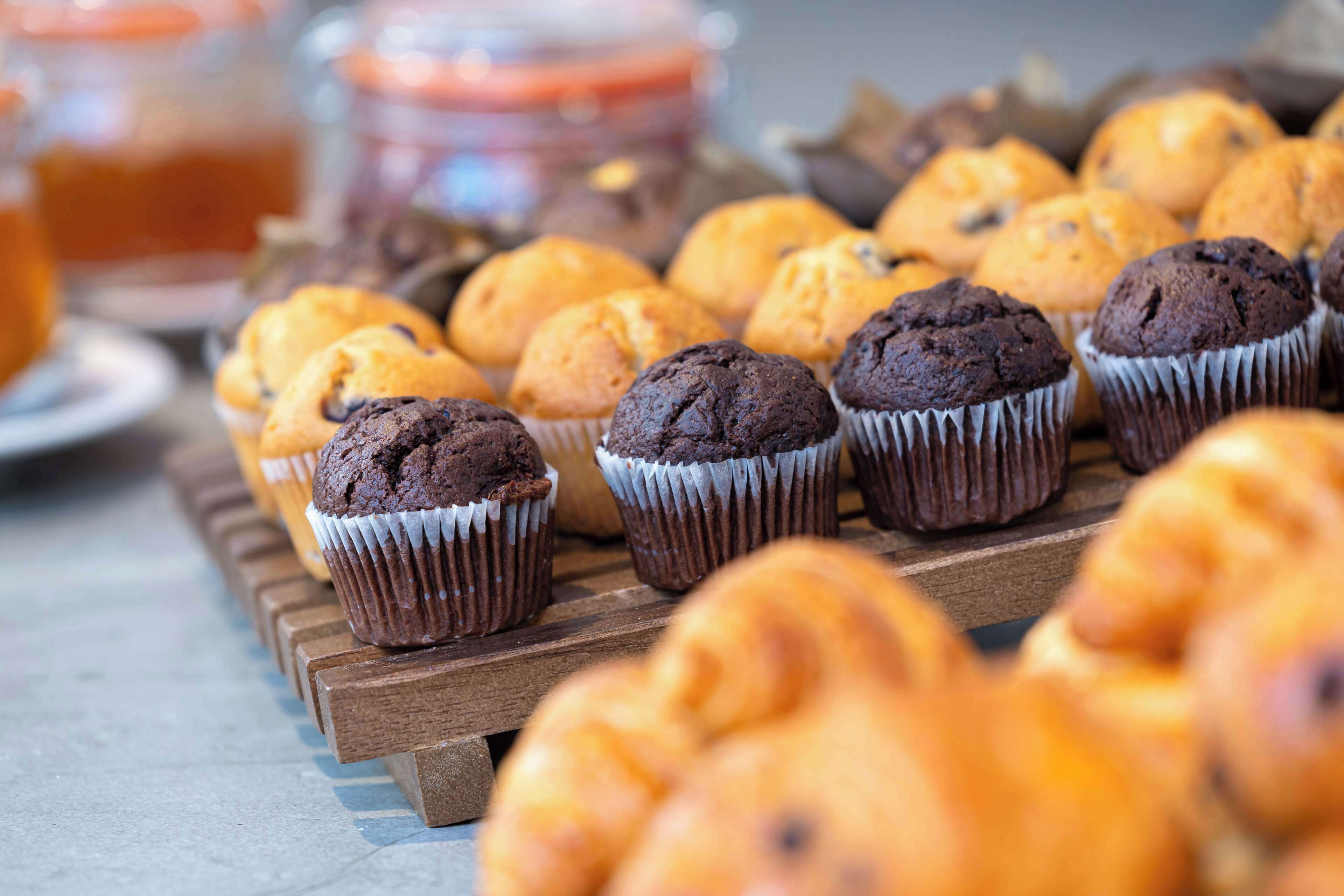 A variety of muffins on a wooden tray.