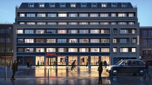 A multi-story hotel with a modern design, featuring a prominent restaurant on the ground floor. - Hampton by Hilton London City (London)