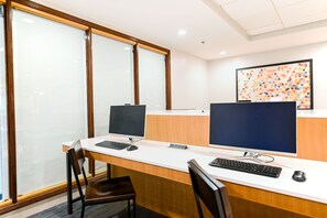 A reception desk with two computer monitors, a keyboard, and a mouse.