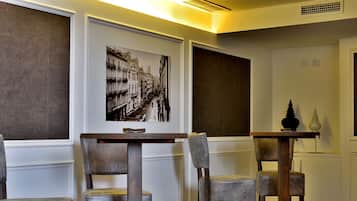 A dining area with a table and four chairs, a wall-mounted picture, and a small decorative item on a table.