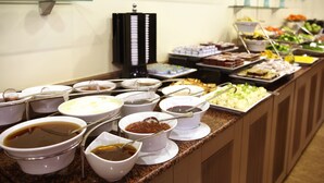 Un bufé con diversas opciones de comida, incluyendo tazones de sopa y ensalada.