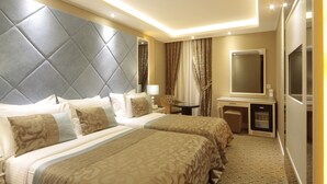 Una habitación de hotel con dos camas, televisión, escritorio y minibar.