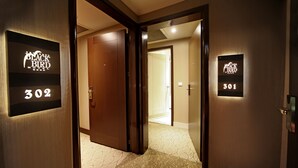 Pasillo de hotel con puertas identificadas como 'Black Bird' y números de habitación '302' y '301'.