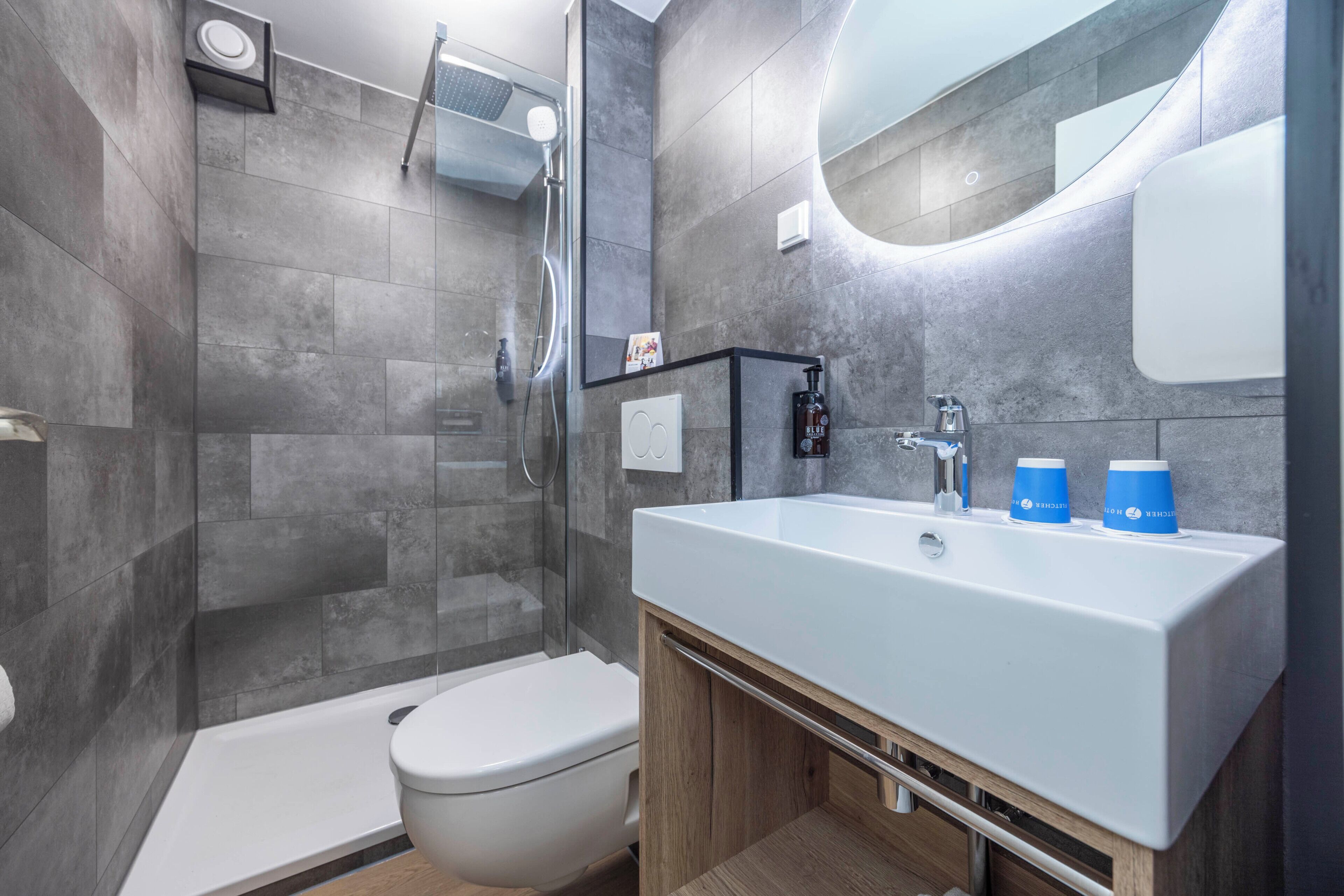 A modern bathroom with a shower, toilet, and sink.