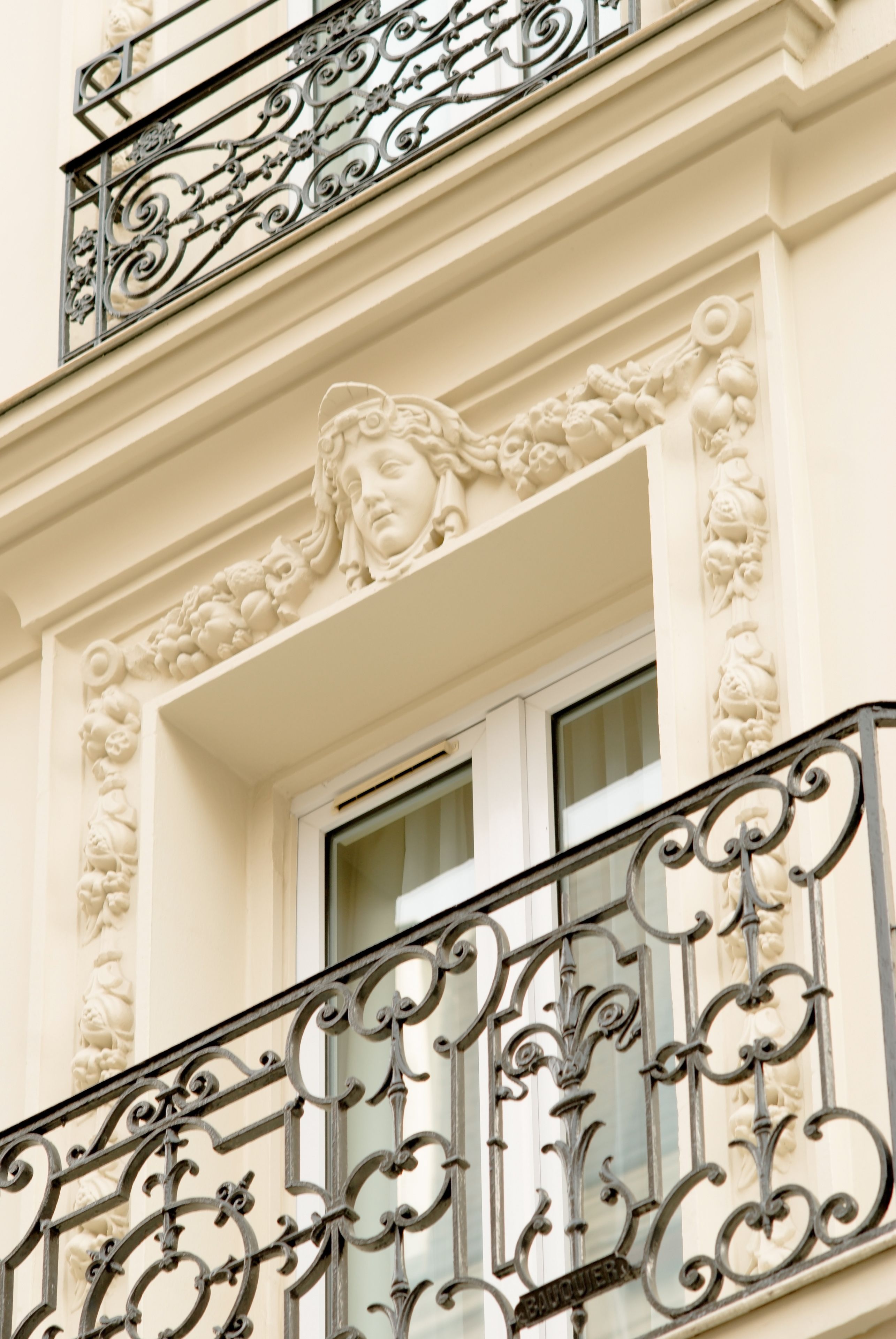 A building facade with ornate iron balcony railings and classical architectural details.