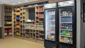 En automatområde med hylder fyldt med snacks, drikkevarer og frossen mad.