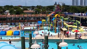 A water park with multiple pools and slides, surrounded by beach chairs and umbrellas. - Hampton Inn Daytona/Ormond Beach (Ormond Beach)