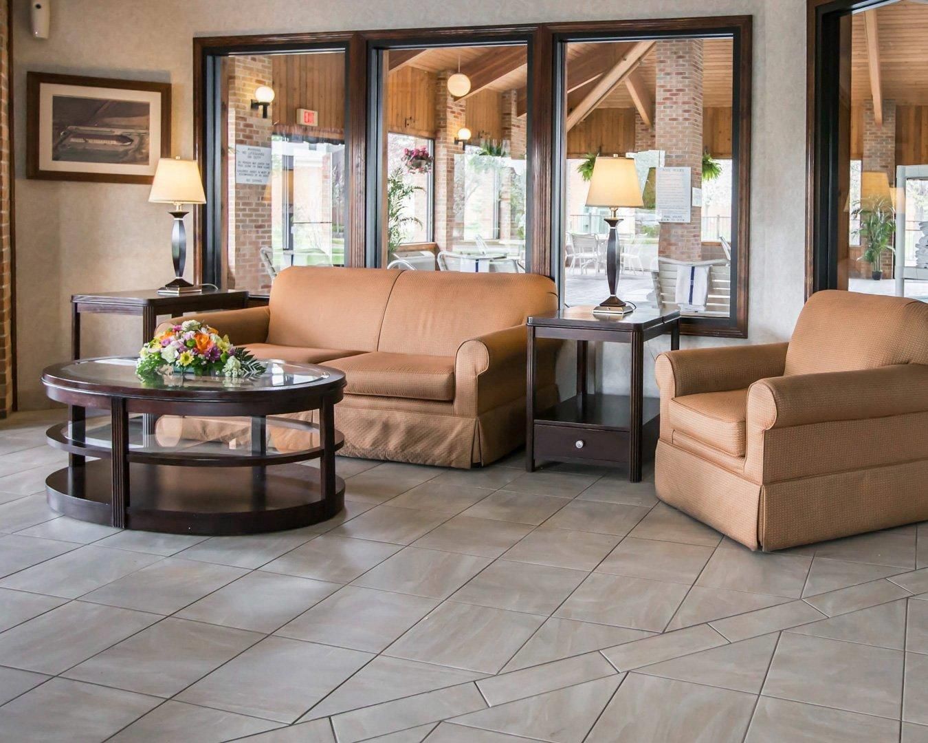 A seating area with a round table, two armchairs, and a small side table with lamps.