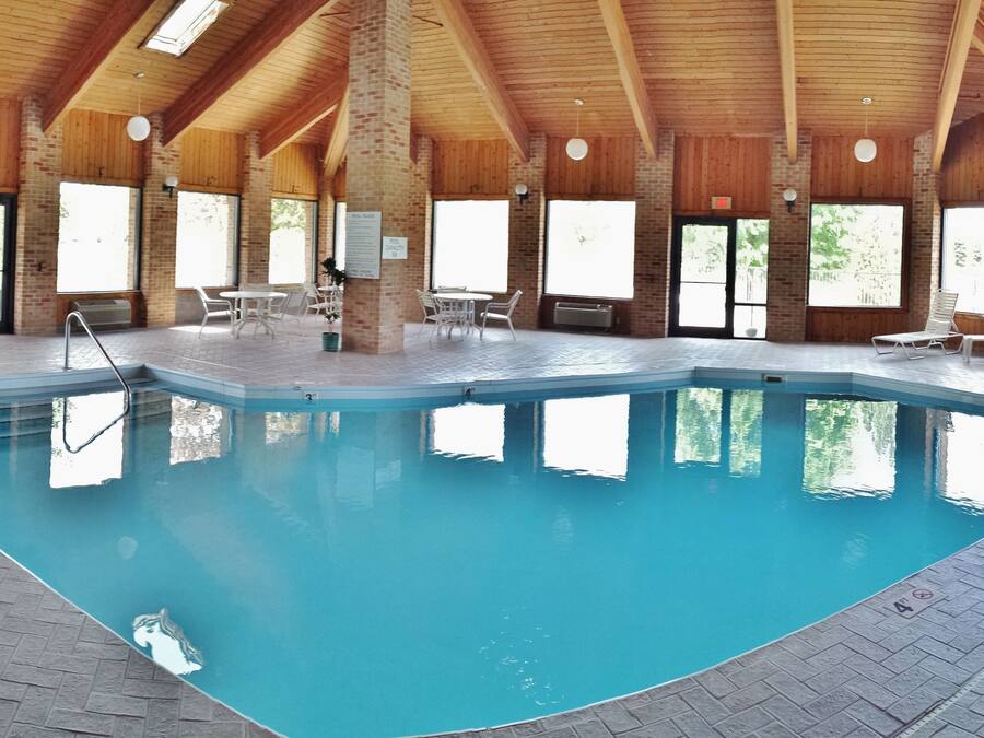 Een binnenzwembad, ligstoelen bij het zwembad