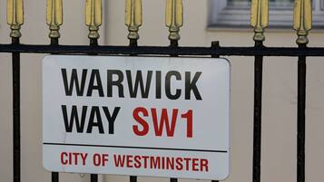 A sign on a fence reading "Warwick Way SW1" and "City of Westminster".