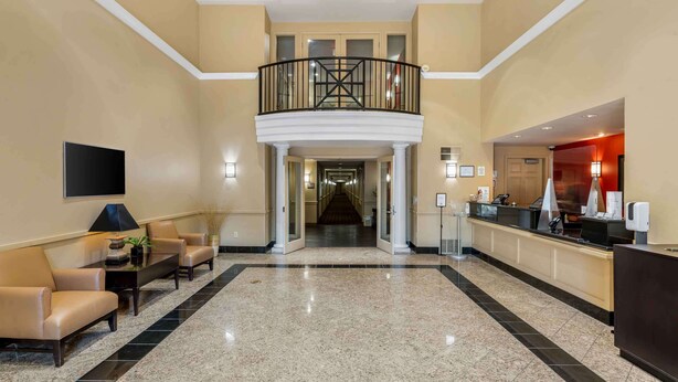 A spacious lobby with a high ceiling, a central staircase, and a reception desk. - Extended Stay America Suites Portland Hillsboro (Hillsboro)