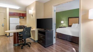 A hotel room with a bed, a desk with a chair, a television, a microwave, and a small kitchenette. - Extended Stay America Suites Portland Hillsboro (Hillsboro)