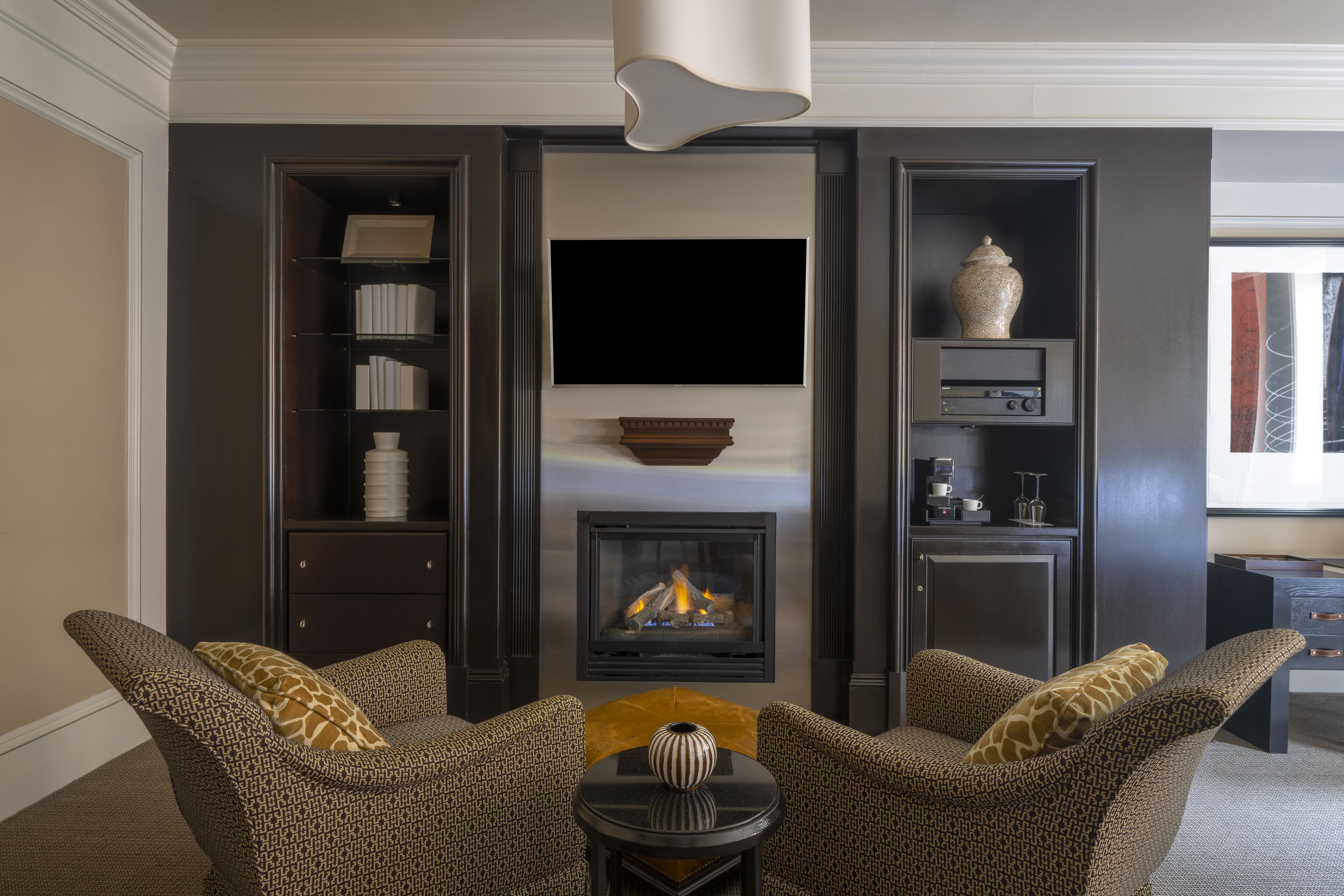 Una sala de estar moderna con chimenea, un televisor de pantalla plana y una estantería.