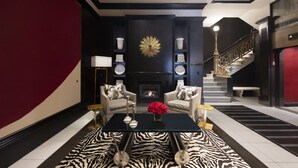 A modern living room with a fireplace, two armchairs, a coffee table, and a zebra-patterned rug. - XV Beacon (Boston)