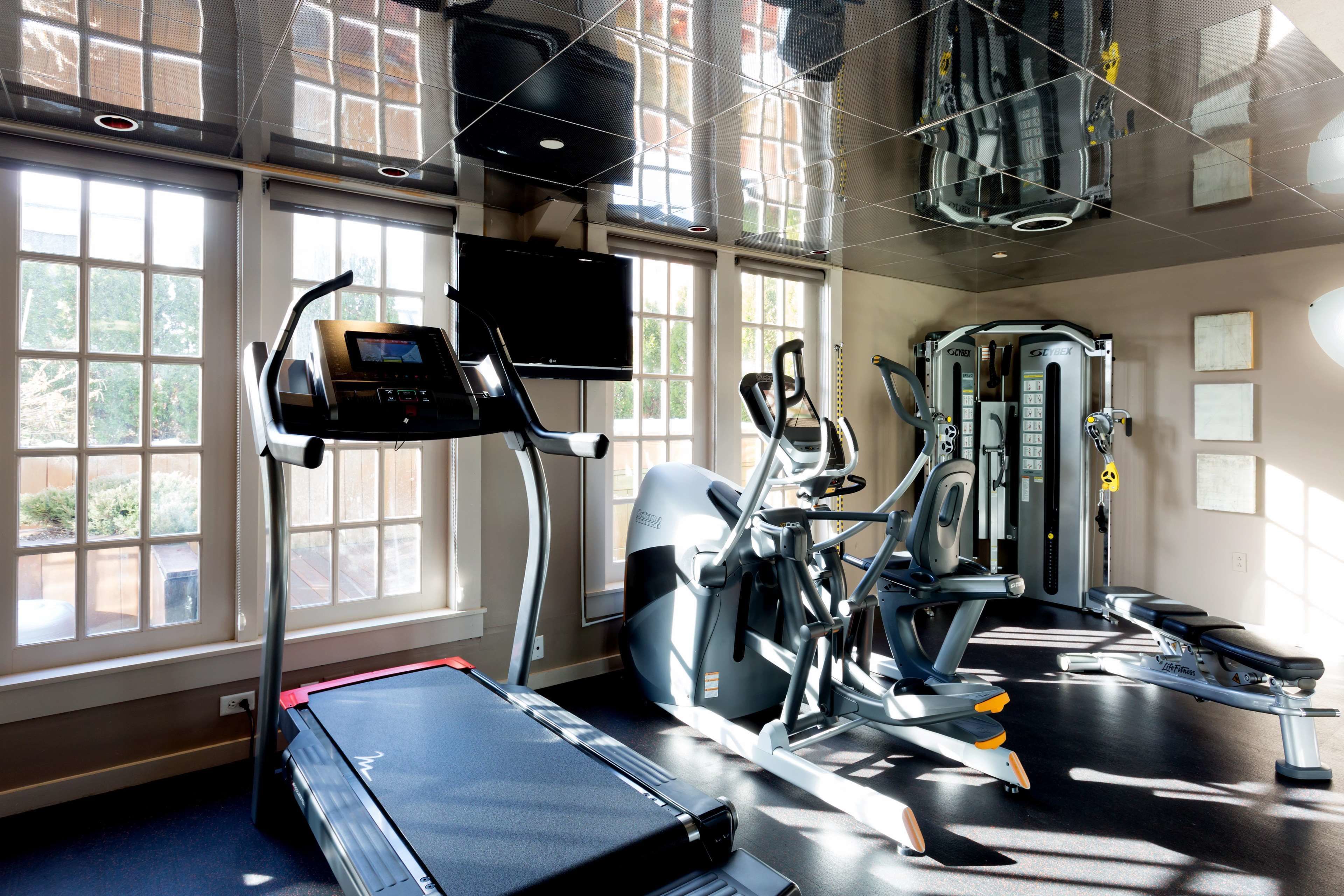 A gym with treadmills, elliptical machines, and weight equipment.