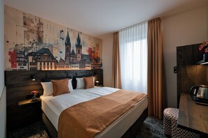 A hotel room with a large cityscape mural, a bed with a brown blanket, a nightstand with a lamp, and a wooden wardrobe.