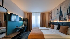 Une chambre d’hôtel avec un lit, un bureau, une chaise, une télévision et un grand tableau représentant un paysage urbain accroché au mur.