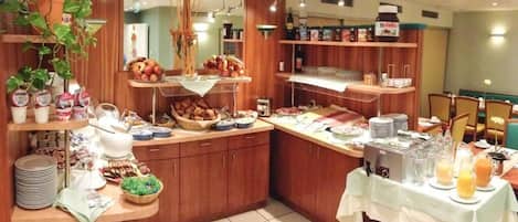 Un bufé de desayuno con diferentes opciones de comida y una estación de zumos.