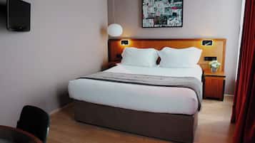 Habitación de hotel con cama, mesitas de noche, televisor montado en la pared y una obra de arte en la pared.