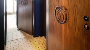 A hallway with wooden doors, a patterned floor, and a visible door handle. - Hôtel Châteaudun Opéra (Paris)