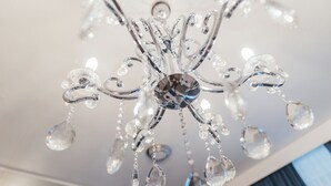 A chandelier with multiple crystal elements and a central reflective piece.