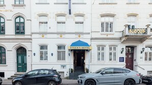 A white building with a blue awning labeled "Steen's Hotel".