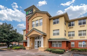 A hotel with a lobby entrance, multiple windows, and a sign indicating extended stay availability. - Extended Stay America Suites Orlando Southpark Commodity Cir (Orlando)