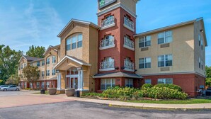 A Stay America hotel with a central tower, multiple balconies, and a well-maintained exterior. - Extended Stay America Suites Indianapolis Northwest I465 (Indianapolis)