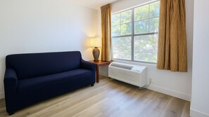 Suite, 2 camas dobles, no fumadores | Zona de estar | Televisión de pantalla plana de 32 pulgadas con canales por cable