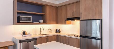 Una cocina moderna con armarios de madera, un refrigerador de acero inoxidable, un microondas y un lavavajillas.