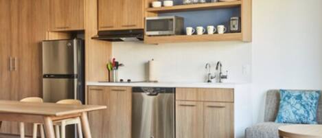 A modern kitchen with wooden cabinets, stainless steel appliances, and a built-in microwave shelf.
