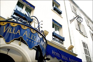 A sign for Villa Alessandro Hotel with a decorative metal frame and a blue awning.