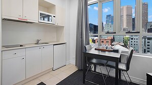 Una cocina moderna con armarios blancos, un microondas y una ventana con vistas a la ciudad.