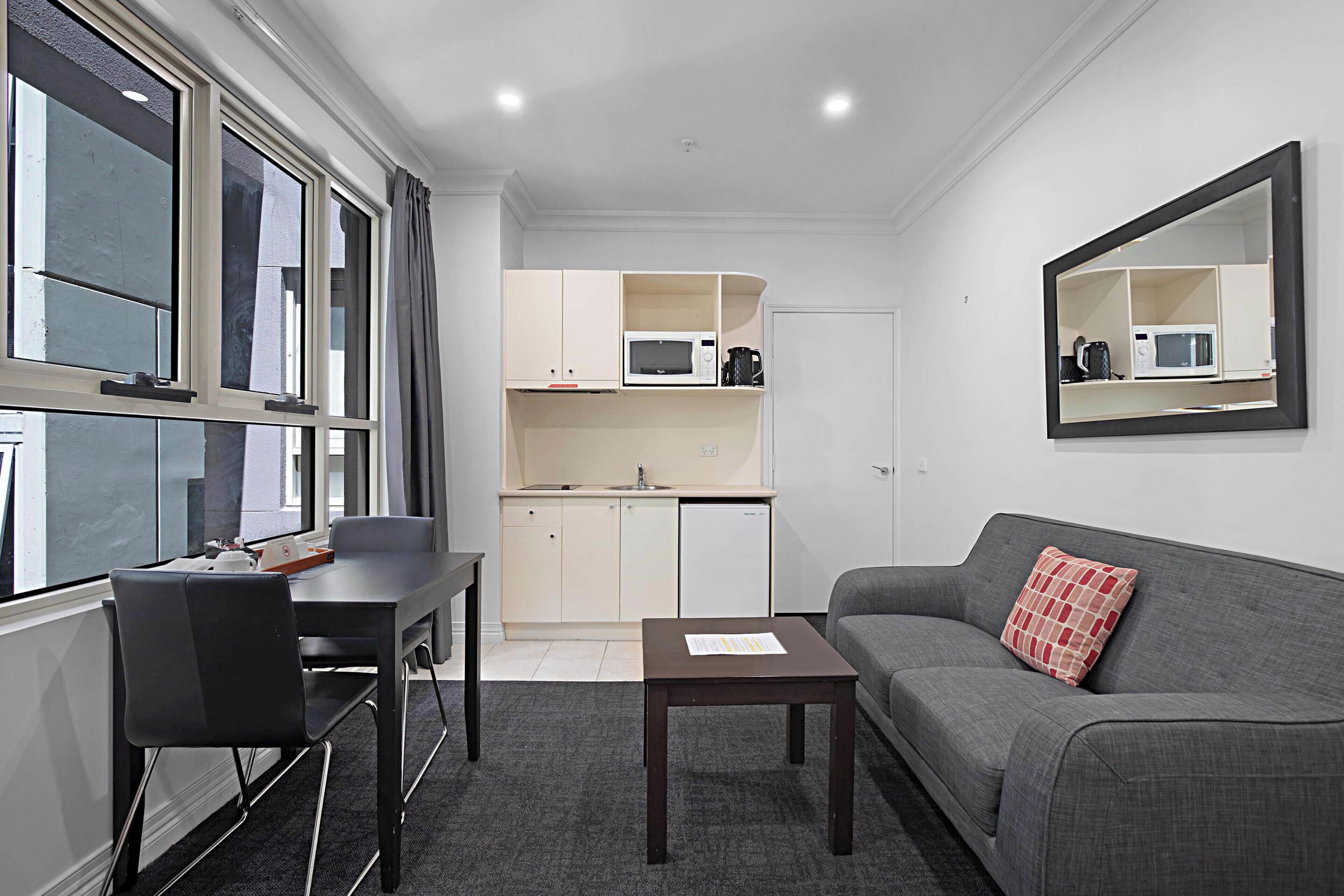 A compact living space with a kitchenette, a dining area, and a seating area.