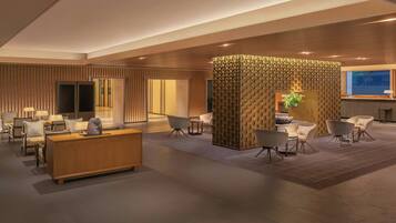 A modern lobby with a reception desk, seating area, and a decorative wall.