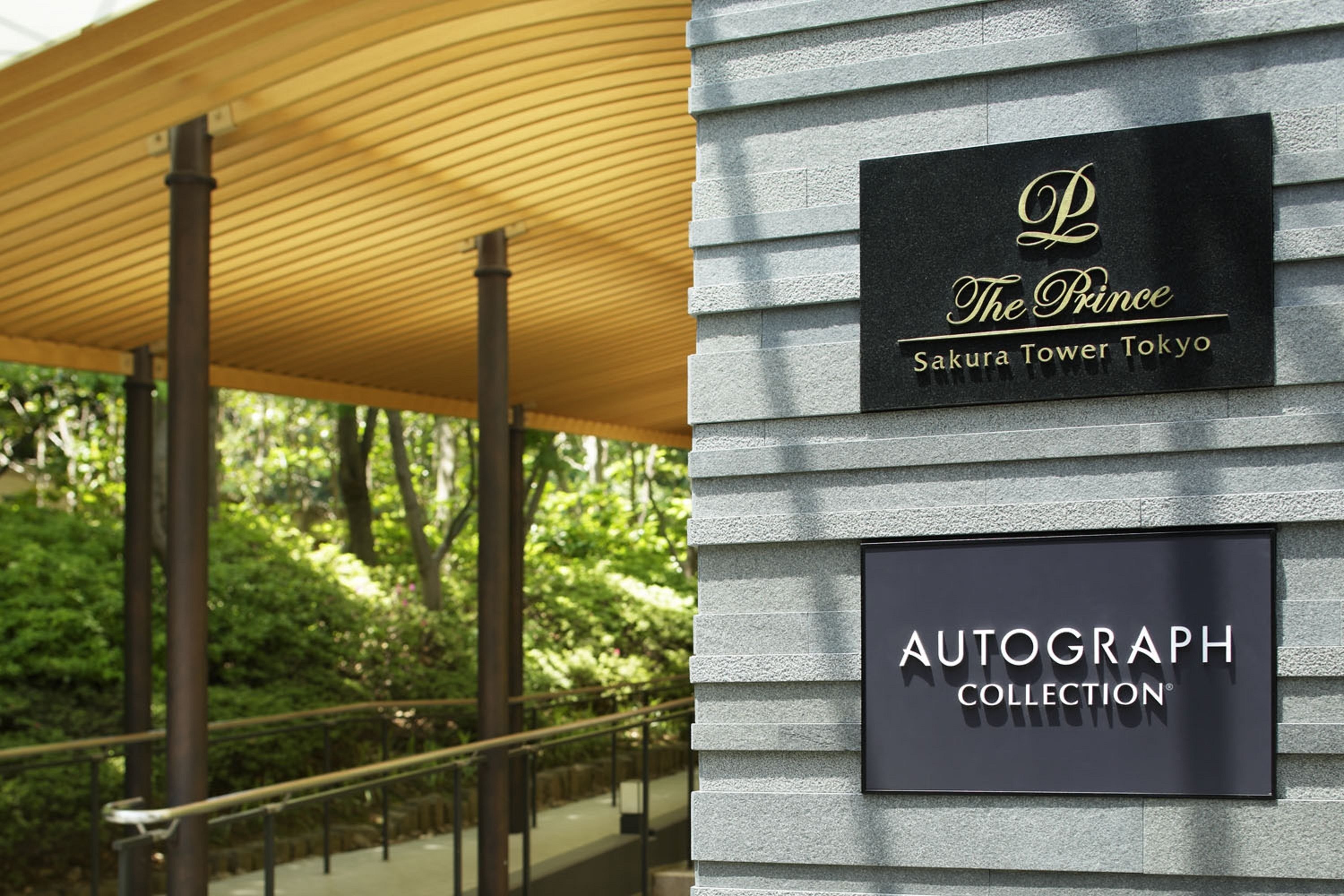 A building facade with signage for "The Prince Sakura Tower Tokyo" and "Autograph Collection."